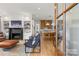 Open-concept living room featuring a fireplace, hardwood floors, and views of the modern kitchen at 113 Prince St, Belmont, NC 28012
