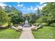 Park view showcasing a war memorial statue surrounded by lush greenery and clear sky at 113 Prince St, Belmont, NC 28012