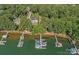 Aerial view of a waterfront home with a dock and multiple boats, surrounded by lush greenery and water at 116 Ivy Hollow Ln, Mooresville, NC 28117