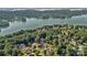 Overhead view showcasing the neighborhood, surrounding lush trees, and lake in the distance on a sunny day at 116 Ivy Hollow Ln, Mooresville, NC 28117