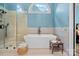 Luxurious bathroom with a freestanding tub, glass-enclosed shower, and a half-moon window for natural light at 116 Ivy Hollow Ln, Mooresville, NC 28117