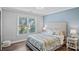 Serene bedroom with a floral patterned comforter, upholstered headboard, and a window overlooking the neighborhood at 116 Ivy Hollow Ln, Mooresville, NC 28117