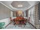 Dining room with tray ceiling, elegant chandelier, and large table, perfect for entertaining guests at 116 Ivy Hollow Ln, Mooresville, NC 28117
