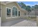 Exterior angle of home with large deck, an arched window, neutral siding, and surrounding greenery at 116 Ivy Hollow Ln, Mooresville, NC 28117