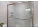 Modern tiled shower featuring glass doors, a rainfall showerhead, and built-in shelving at 116 Ivy Hollow Ln, Mooresville, NC 28117