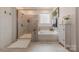 Bright bathroom featuring shower, tub, and a decorative cabinet for storage at 1178 Arges River Dr, Fort Mill, SC 29715