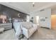 Elegant primary bedroom with a tray ceiling, wainscoting accent wall, and bright, natural light at 1178 Arges River Dr, Fort Mill, SC 29715