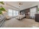 Elegant primary bedroom with a tray ceiling, wainscoting accent wall, and bright, natural light at 1178 Arges River Dr, Fort Mill, SC 29715