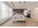 Elegant primary bedroom with a tray ceiling, wainscoting accent wall, and bright, natural light at 1178 Arges River Dr, Fort Mill, SC 29715