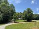 Exterior view of the home and gravel driveway, surrounded by lush greenery and trees at 121 C & K Dr # 60, Taylorsville, NC 28681