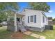Charming home featuring white siding, blue shutters, a cozy porch and a well-maintained yard at 123 E Farmview St, Gastonia, NC 28054