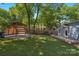 Expansive backyard featuring a covered parking area, lush lawn, and mature trees providing shade at 1500 Pecan Ave, Charlotte, NC 28205