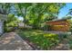 Grassy backyard with a covered parking area, wooden fence, landscaping and a deck and stone pathway at 1500 Pecan Ave, Charlotte, NC 28205