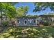 Backyard featuring a blue house, stone pathway, lush lawn, and surrounded by mature trees at 1500 Pecan Ave, Charlotte, NC 28205