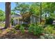 Charming home exterior with lush landscaping, a blue house and mature trees in the front yard at 1500 Pecan Ave, Charlotte, NC 28205