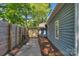 Exterior side yard with wooden fence and wood pathway, with a yellow shed and blue house at 1500 Pecan Ave, Charlotte, NC 28205
