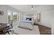 Sunlit main bedroom featuring a cozy bed with blue accents, a ceiling fan, and ample closet space at 17931 Kings Point Dr # E, Cornelius, NC 28031