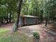 Shed features covered porch, and is surrounded by mature trees at 200 Breslin St, Wadesboro, NC 28170