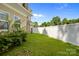 Private backyard with white fence, green grass, and lush landscaping at 2117 Middlebridge Ct, Fort Mill, SC 29715