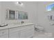 Bathroom featuring white cabinets, quartz countertops, and decorative mirror at 2117 Middlebridge Ct, Fort Mill, SC 29715