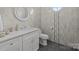 Modern bathroom featuring marble counters, tiled walls, and round mirror at 2117 Middlebridge Ct, Fort Mill, SC 29715