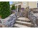Stone steps lead to the front entrance, accented with lush landscaping and mature trees at 2117 Middlebridge Ct, Fort Mill, SC 29715