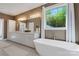 Luxurious bathroom with double sink vanity, a soaking tub by the window, and modern fixtures at 2122 Goose Creek Farm Ln, Indian Trail, NC 28079