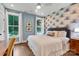 Stylish bedroom boasting a decorative accent wall, large windows, and hardwood floors at 2122 Goose Creek Farm Ln, Indian Trail, NC 28079