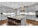 Spacious kitchen featuring a marble island, grey cabinets, stainless steel appliances and hardwood floors at 2122 Goose Creek Farm Ln, Indian Trail, NC 28079
