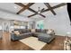 Bright living room open to kitchen with beamed ceiling, fan, and hardwood flooring at 2122 Goose Creek Farm Ln, Indian Trail, NC 28079