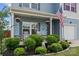 Inviting front porch with rocking chairs and decorative plants, enhanced by lush landscaping at 214 Hidden Lakes Rd, Statesville, NC 28677