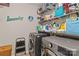 This is a well-lit laundry room with a washer and dryer with wire shelving for ample storage of cleaning supplies at 214 Hidden Lakes Rd, Statesville, NC 28677