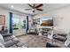 Cozy living room featuring a ceiling fan, large windows, and a modern entertainment center with a fireplace at 214 Hidden Lakes Rd, Statesville, NC 28677
