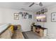This loft area features a tan couch, mounted TV with shelves of books, and decorative art on the walls at 214 Hidden Lakes Rd, Statesville, NC 28677