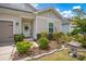 View of a nicely landscaped home with a decorative front door, adorned with vibrant plants and a stone lantern at 2473 Riparian Way, Denver, NC 28037