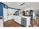 A modern kitchen features a large island, stainless steel appliances, and sleek white cabinetry at 2473 Riparian Way, Denver, NC 28037