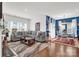 Bright and open living area with a large sectional sofa and hardwood floors flows seamlessly into the dining area at 2473 Riparian Way, Denver, NC 28037