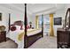 Spacious bedroom with a four-poster bed, tray ceiling, and lots of natural light at 2473 Riparian Way, Denver, NC 28037