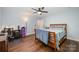 Bedroom featuring ceiling fan, desk area, hardwood floors, and soft blue walls at 3041 Shallowood Ln, Charlotte, NC 28277