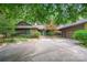 Charming home featuring a stone and siding exterior, lush landscaping, and a spacious driveway at 3041 Shallowood Ln, Charlotte, NC 28277