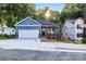 Charming blue house with a garage and brick accents on a sunny day, new construction at 354 Moore Ave, Mooresville, NC 28115