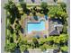 Aerial shot of the community pool surrounded by shrubbery, umbrellas and lounge chairs at 4024 Town Center Rd, Harrisburg, NC 28075