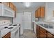 Efficient kitchen featuring white appliances, wood cabinets and neutral flooring at 4024 Town Center Rd, Harrisburg, NC 28075