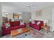 Inviting living room with red couches, ceiling fan, and access to the kitchen at 4024 Town Center Rd, Harrisburg, NC 28075
