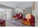 Bright living room with plush red sofas, a ceiling fan, and a view into the dining area at 4024 Town Center Rd, Harrisburg, NC 28075