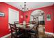 The dining room features a chandelier, bright red walls, and an open archway leading to the living room at 4441 Jim Wise Rd, Lincolnton, NC 28092