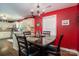 Open-concept dining room with modern chandelier, red walls, and views into the kitchen area at 4441 Jim Wise Rd, Lincolnton, NC 28092