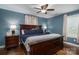 Primary bedroom featuring a dark wood bed frame, blue walls, hardwood floors, and ceiling fan at 4441 Jim Wise Rd, Lincolnton, NC 28092