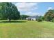 Expansive backyard featuring a lush lawn, mature trees, and a charming deck, perfect for outdoor entertaining at 5211 Spring Gln, York, SC 29745