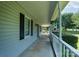Side view of the covered porch with white posts and black shutters at 5211 Spring Gln, York, SC 29745